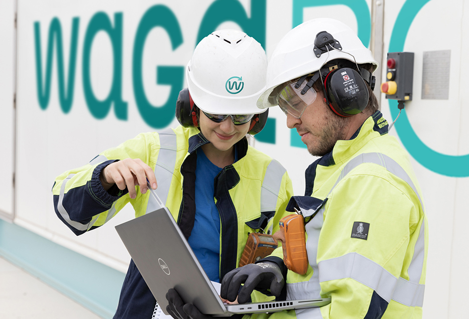 Images représentants deux collaborateurs de Waga Energy travaillant devant une unité WAGABOX.