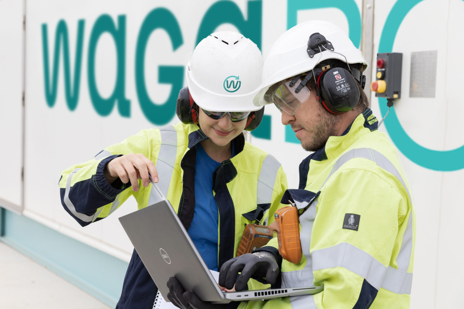 Images représentants deux collaborateurs de Waga Energy travaillant devant une unité WAGABOX.